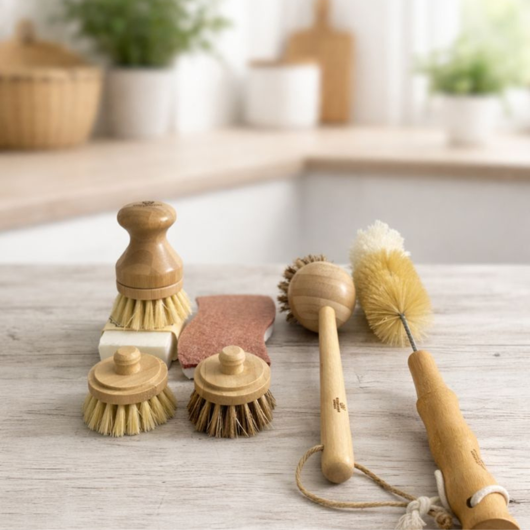 Set of cleaning brushes and sponges on a wooden surface