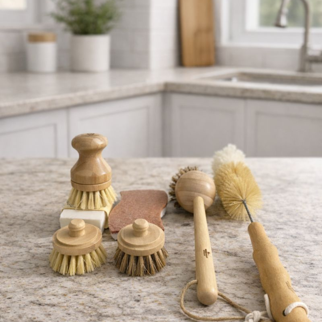 Set of wooden cleaning brushes and sponges on a kitchen counter.