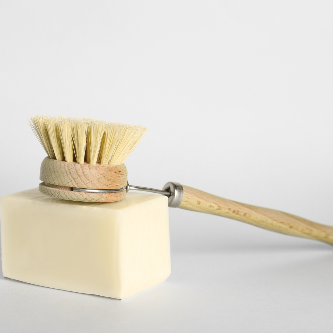 Dish brush with wooden handle and natural bristles on a white background