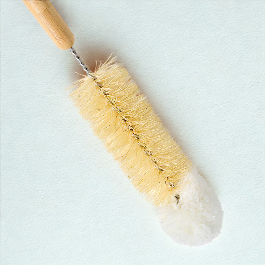 Bottle brush with wooden handle and natural bristles on a light blue background