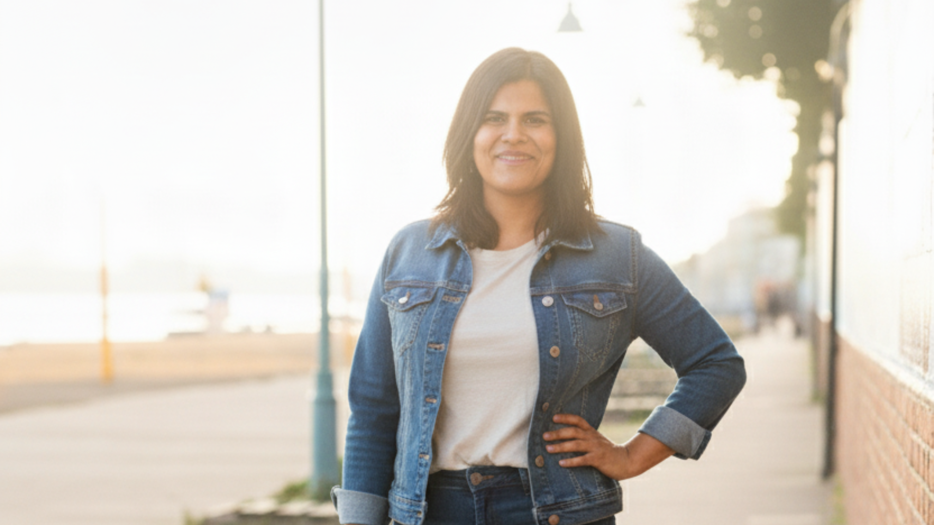 Eco Haven Head wearing a denim jacket standing on a street with blurred background