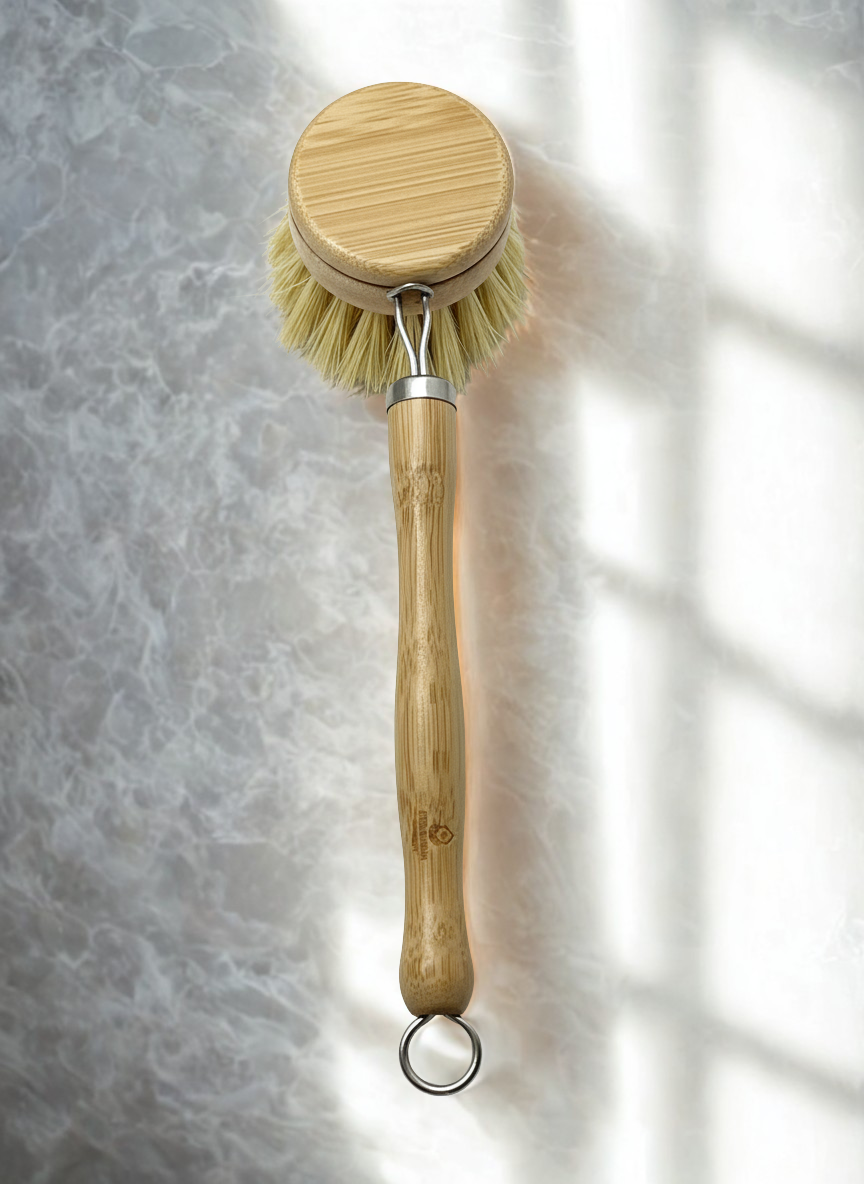 Bamboo dish brush with a round head on a textured gray background